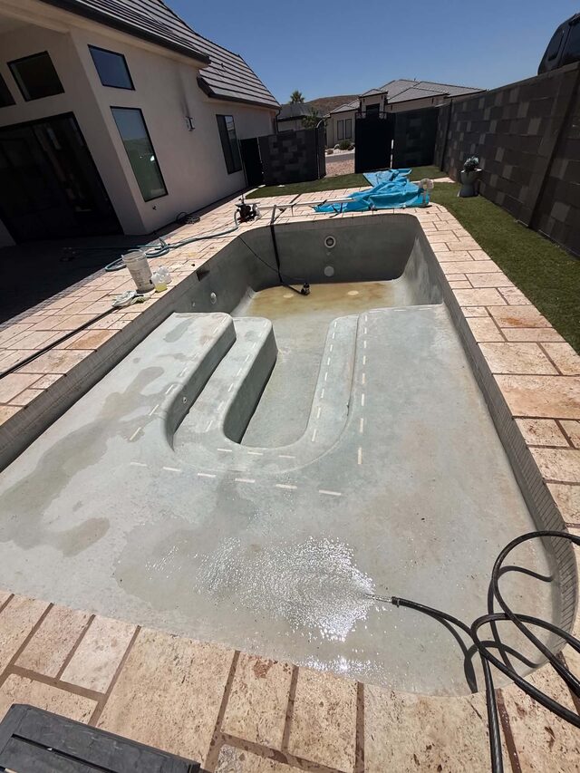 Drained pool being scrubbed and cleaned
