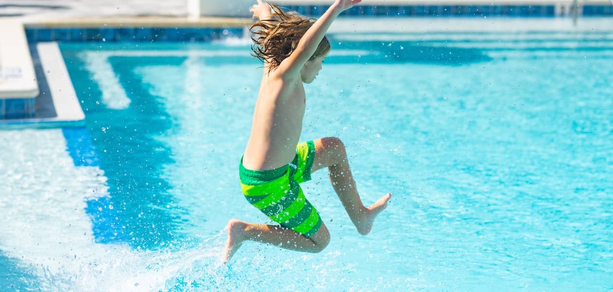 Kid jumping into pool