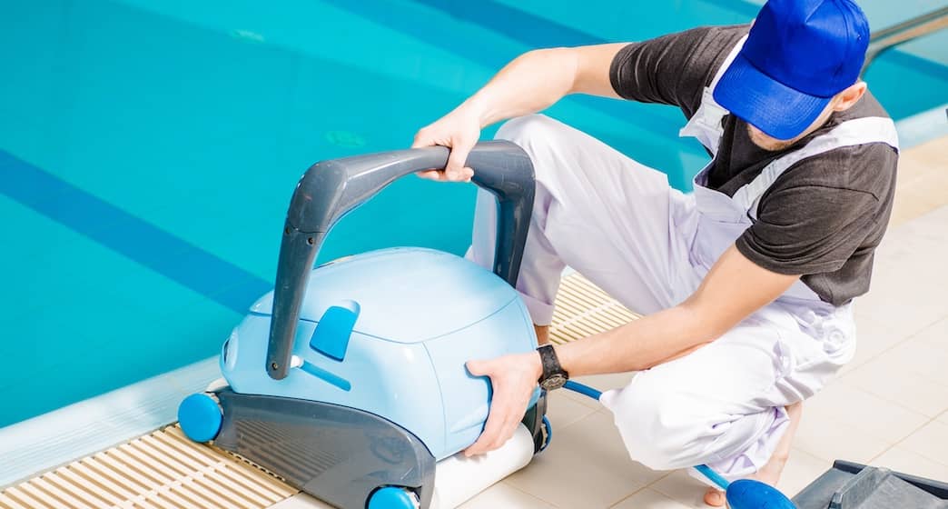 Man cleaning pool with a vacuum